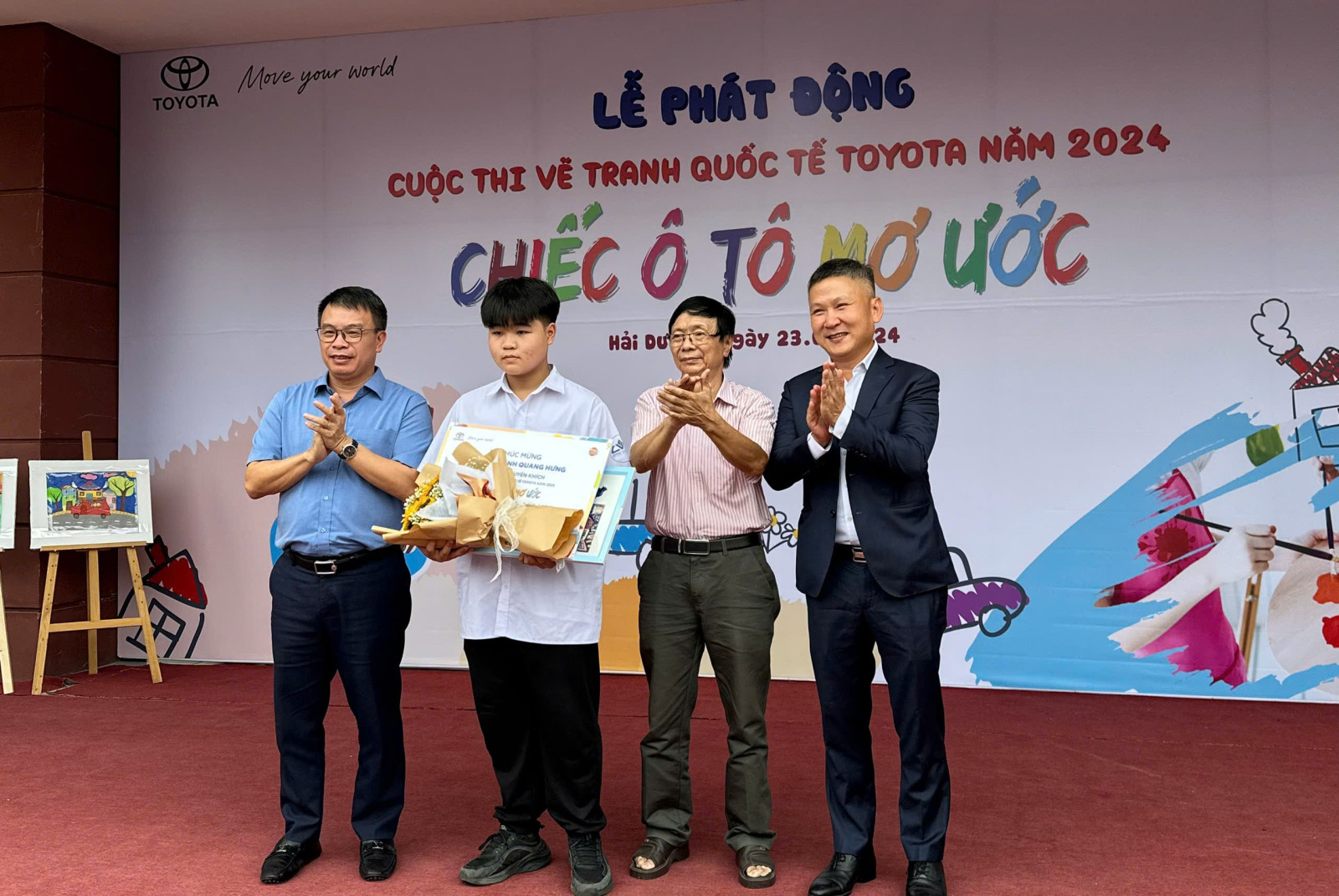 Đại diện Toyota Việt Nam trao tặng kỷ niệm chương cho em Đinh Quang Hưng - Tác giả của bức tranh đạt giải Khuyến khích vòng thi quốc tế năm 2023.